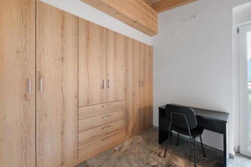 a room with wooden cabinets and a black desk at La Villa di Ludo in San Cassiano