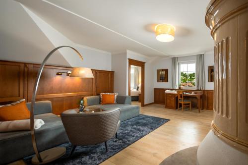 a living room with a couch and a table at Wellness- & Sporthotel Jagdhof in Röhrnbach