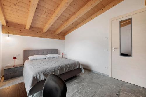a bedroom with a bed and a wooden ceiling at La Villa di Ludo in San Cassiano