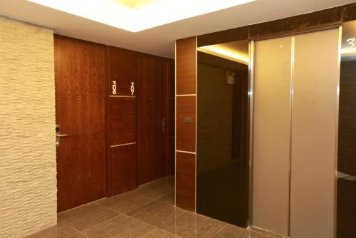 a bathroom with wooden doors and a walk in closet at The Bangkok Airport Link Suite - SHA Plus in Bangkok