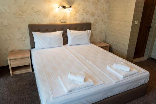 a bedroom with a large bed with two towels on it at Tarnovka - Guest Rooms in Veliko Tŭrnovo
