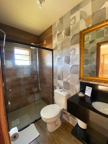 a bathroom with a toilet and a shower and a sink at Pousada Ondas do Embaú in Palhoça