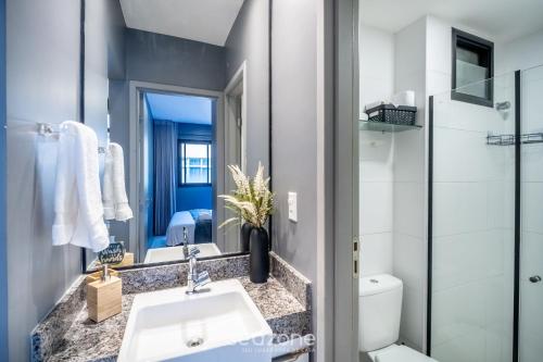 a bathroom with a sink and a toilet and a mirror at Apart in Condo w/ Pool and Gym STE0312 in Salvador