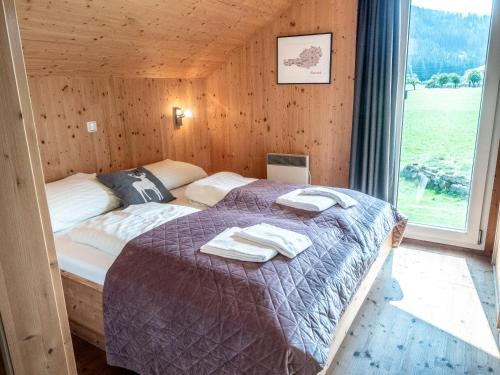 a bedroom with a bed with towels on it at Woody Park Feriendorf Murau in Murau