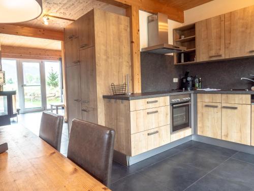 a kitchen with wooden cabinets and a table and chairs at Woody Park Feriendorf Murau in Murau