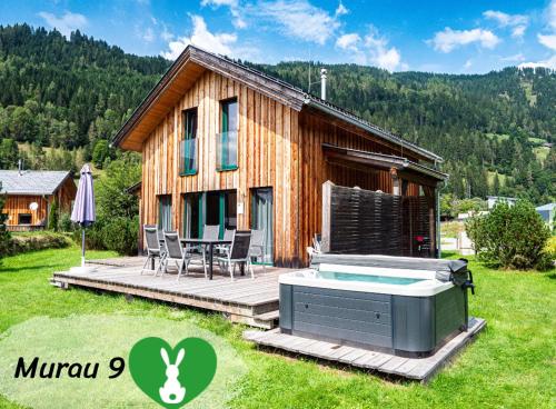 a small house with a hot tub in the yard at Woody Park Feriendorf Murau in Murau