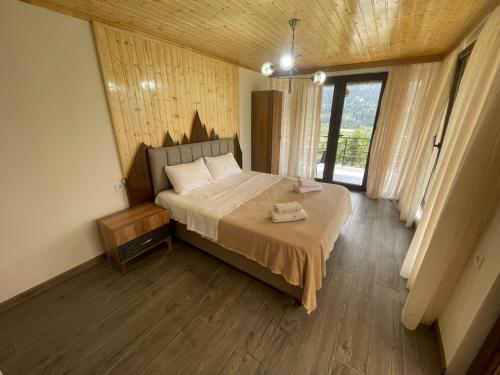 a bedroom with a bed and a large window at Nadia Guesthouse in Mestia
