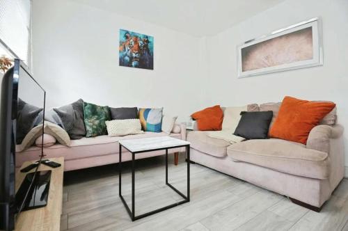 a living room with two couches and a table at Stylish 5 Bed House Centre Of Coventry Sleeps 12 in Exhall