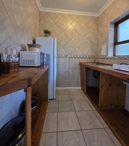 a kitchen with a white refrigerator and a sink at East London - Airport - Birder Paradise Units in Gulu