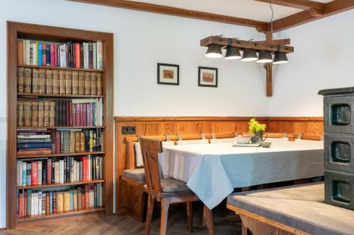 a dining room with a table and bookshelves at Schennach Apartment in Reutte
