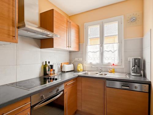 une petite cuisine avec un évier et une cuisinière dans l'établissement Le 552 en Baie - Gîte 4 à 7 personnes avec parking, à Saint-Valery-sur-Somme