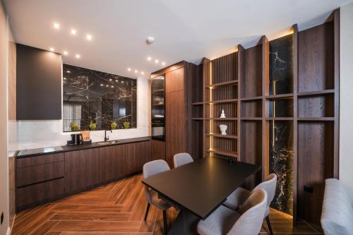a dining room with a black table and white chairs at Ideal Apartments in Banja Luka