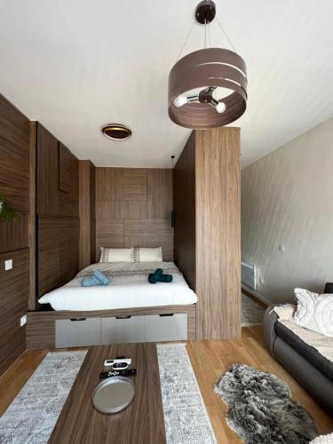 un dormitorio con una cama y una mesa en Mitra Apartmani, en Zlatibor