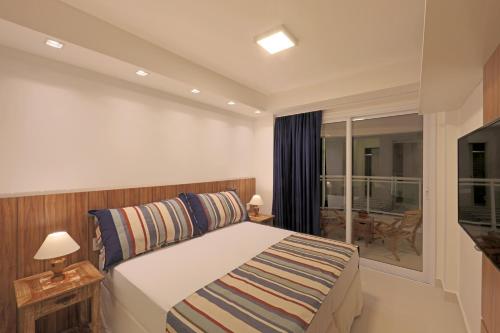 una camera d'albergo con un letto e un balcone di In Mare Bali Apto Residencial Resort a Parnamirim