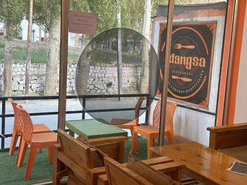 a restaurant with a table and chairs and a mirror at Rdangsa homestay and restaurant ladakh in Leh