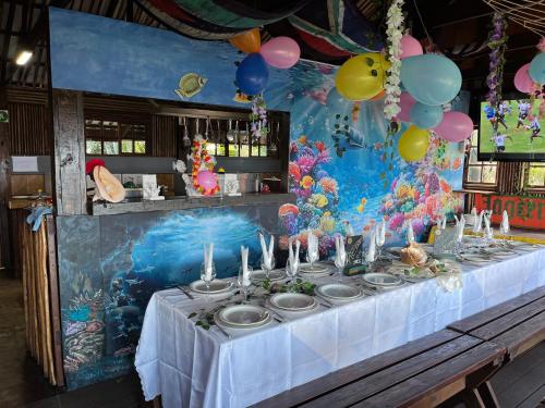 a table with a white table cloth and balloons at Moz Inn - Coconut View Resort in Lopes