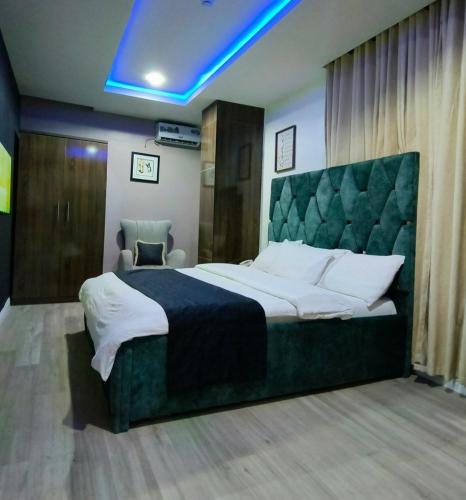 a bedroom with a large bed with a green headboard at Kf Apartments, Swimming pool, Gym, Wifi in Gwarinpa