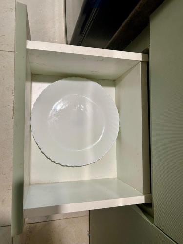 a white plate is inside of a cabinet at Sparsh A Luxury Experience by Stay Haven in Pune