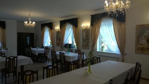 a dining room with tables and chairs and windows at Noclegi Dwór Szlachecki Biedaczów in Biedaczów