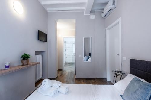a bedroom with a white bed with towels on it at L'arco del pellegrino in Monteroni dʼArbia