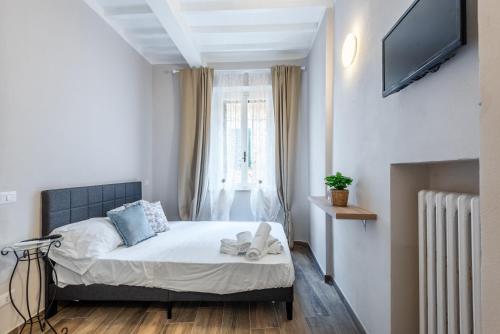 a bedroom with a bed with a tv and a window at L'arco del pellegrino in Monteroni dʼArbia