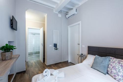 a white bedroom with a bed and a table at L'arco del pellegrino in Monteroni dʼArbia