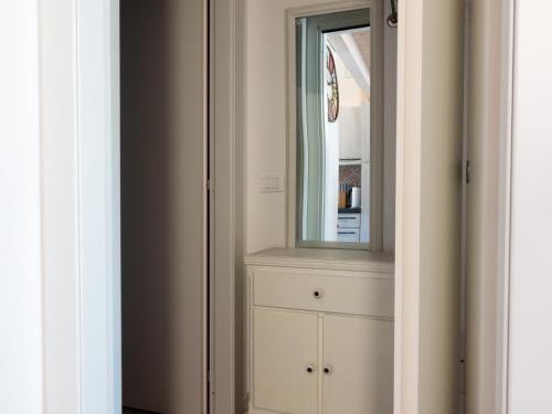a bathroom with a mirror and a white cabinet at Sogno sul Fiume in Sovere