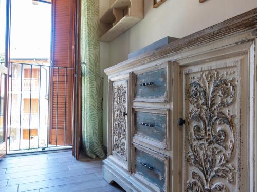 an old wooden cabinet in a room with a window at Sogno sul Fiume in Sovere