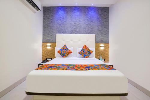 a bedroom with a large white bed with colorful pillows at FabHotel Golden Star in Mumbai