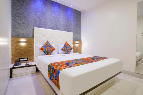 a bedroom with a large white bed with colorful sheets at FabHotel Golden Star in Mumbai