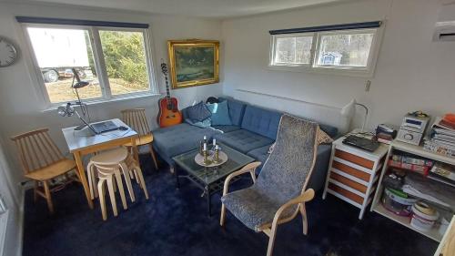 un soggiorno con un divano blu e un tavolo di 2 small cabins beach, boat, fishing, kayaks sauna a Spersboda