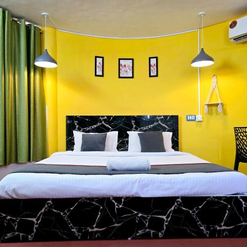 a bedroom with a large bed with yellow walls at Aura Breeze in Pondicherry