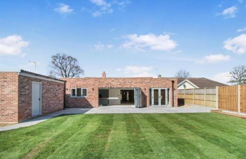 a brick house with a large yard at Detached Home Near Kings Lynn in North Runcton