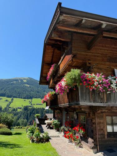 アルプバッハにあるFürstenhäusl Alpbach - GREEN Apartments & Studioの花の横の建物