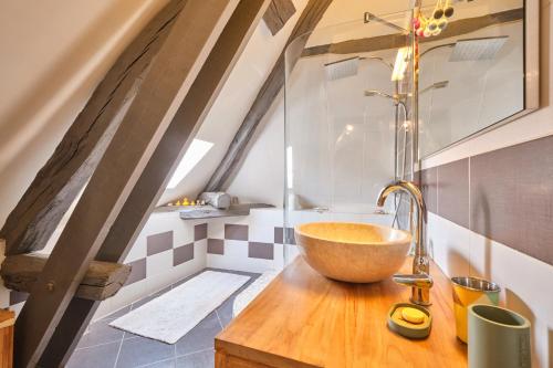 a bathroom with a bowl sink on a wooden counter at Jolie Maison En Pierres in Saint-Martin-de-la-Cluze
