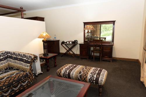 a living room with a couch and a table at Premier Resort Mpongo Private Game Reserve in Macleantown