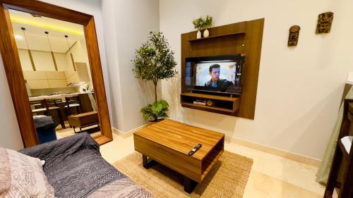 a living room with a couch and a tv at Jungle Guardian - Rooftop Pool & Beach Club in Zona Hotelera Tulum in Tulum