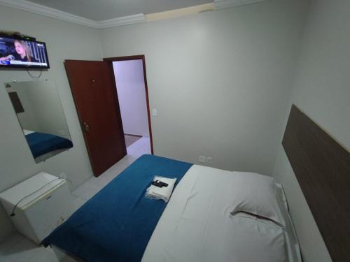 a small bedroom with a bed and a tv at Hotel Abada in Brasília