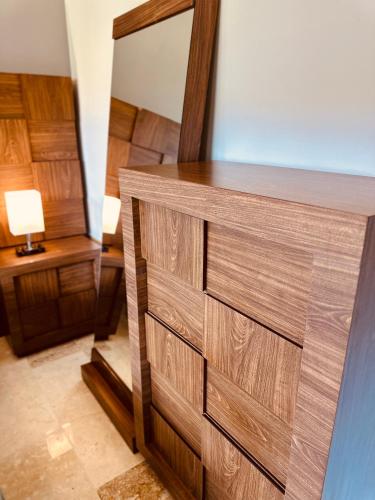 a wooden dresser in a room with a mirror at Jungle Guardian - Rooftop Pool & Beach Club in Zona Hotelera Tulum in Tulum