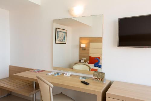 a room with a desk with a large mirror and a table at Blue Horizon in Ialyssos