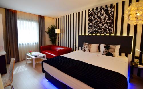 ein Schlafzimmer mit einem großen Bett und einem roten Stuhl in der Unterkunft Tempo Fair Suites in Istanbul