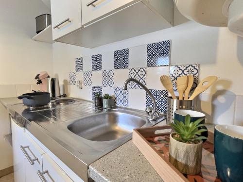 une cuisine avec un évier et un plan de travail dans l'établissement Le Vercors, à Chabeuil