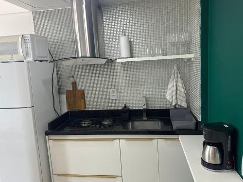 a small kitchen with a sink and a refrigerator at 806 Suite Aquarela do Poente in Manaus