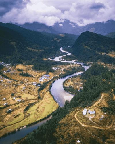 an aerial view of a river in a valley at Odyssey Stays Mechuka in Bāsār