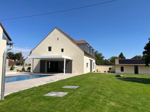 a house with a large yard with a swimming pool at Les Hôtes des Maillets 