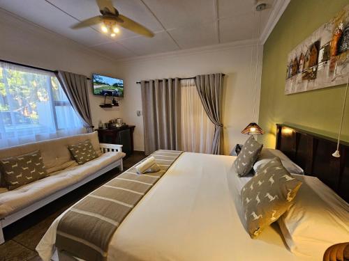 a bedroom with a large bed and a couch at Leopard Corner Lodge in St Lucia