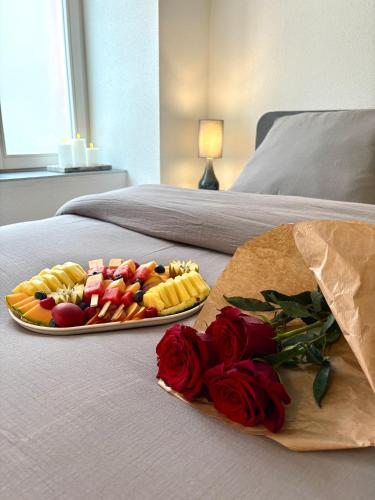 a tray of fruit and vegetables on a bed with roses at Seven Love - Private Spa Sélestat in Sélestat