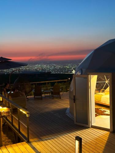 a deck with a tent with a view of a city at EcoHouse Glamping by ART HOTEL in Bishkek