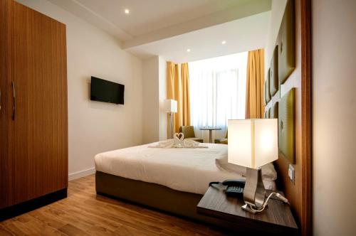 a bedroom with a bed and a lamp on a table at Vatican Relais Rome in Rome