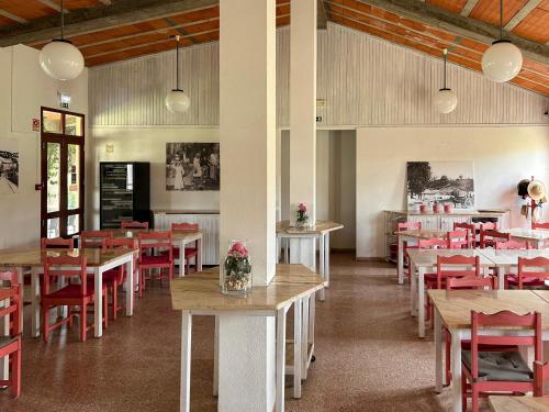 un ristorante con tavoli in legno e sedie rosse di Odeceixe Bungalow-Parque de Campismo Sao Miguel a Odeceixe